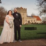 Bride and groom outside a historic church.