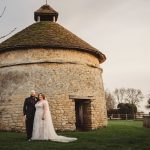 Couple posing by historic stone building