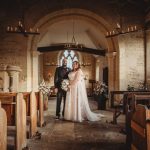 Couple posing in historic church after wedding ceremony.