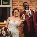 Bride and groom holding ice cream cones, smiling.