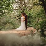 Bride and groom in a lush, green forest.