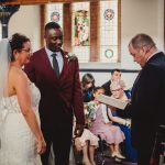 Wedding ceremony in a church with stained glass windows.