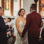 Bride and groom exchanging vows in church ceremony.