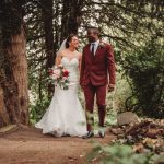 Couple walking in park on wedding day.