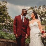 Happy couple walking in garden on wedding day