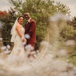 Wedding couple smiling in a garden setting.