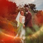 Wedding couple standing in vibrant garden scenery.