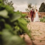 Bride and groom walking in garden path