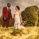 Wedding couple in field of yellow flowers.