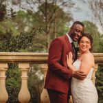 Happy couple embraces outdoors on wedding day.