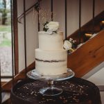 Two-tier wedding cake with white flowers.