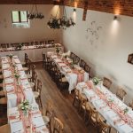 Elegant rustic wedding reception setup with decorated tables.