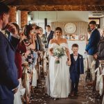 Bride walking down aisle with young boy