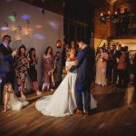 Bride and groom dancing surrounded by guests.