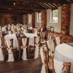 Rustic wedding venue interior with decorated tables.