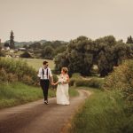 Bride and groom walking on rural path