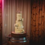 Three-tier wedding cake with floral decorations.