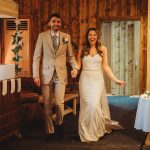 Happy newlyweds entering wedding reception venue.