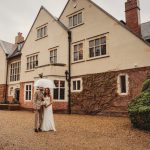 Bride and groom outside historic English manor