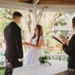 Couple exchanging vows during outdoor wedding ceremony.