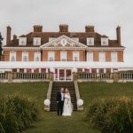 Elegant manor wedding couple pose on lawn