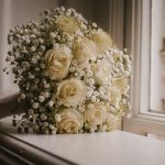 White rose wedding bouquet on window sill.