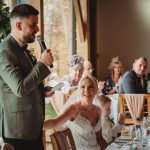 Man giving speech at wedding reception.