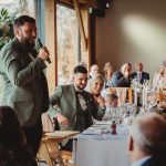 Wedding speech with guests at reception table.