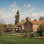 Countryside barn and church on a clear day.