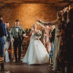 Bride and groom walking through confetti shower.