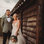 Bride and groom smiling at rustic wedding venue.