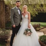 Smiling couple in wedding attire outdoors