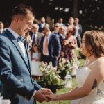 Bride and groom exchanging vows outdoors.