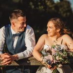 Happy couple smiling during sunny outdoor wedding