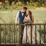 Bride and groom on garden bridge with bouquet