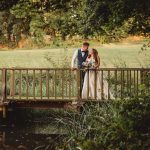 Bride and groom on scenic wooden bridge