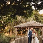 Happy couple under gazebo in lush garden setting.