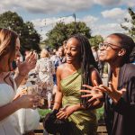 Guests laughing together at outdoor wedding reception.