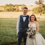 Bride and groom in countryside setting.