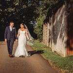 Bride and groom walking outdoors on wedding day.