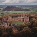 Aerial view of historic castle in lush countryside.