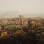 Aerial view of a misty countryside castle.