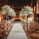 Elegant wedding aisle with white floral decorations.