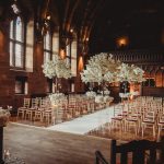 Elegant wedding venue with floral decorations and chairs.