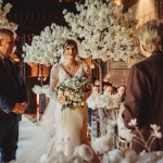 Bride and groom during wedding ceremony with flowers.