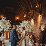 Wedding ceremony in a historical venue with blossoms.