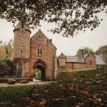 Historic stone building surrounded by autumn trees.