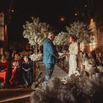 Couple exchanging vows at indoor wedding ceremony.