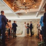 Indoor wedding ceremony with guests and officiant.