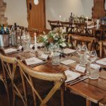 Rustic wedding reception table with candles and flowers.